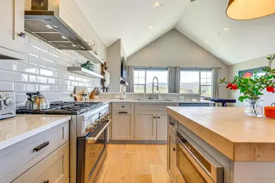 a kitchen with white cabinets and a stove top oven at Hot Tub and Mtn Views Townhome in Granby! in Granby