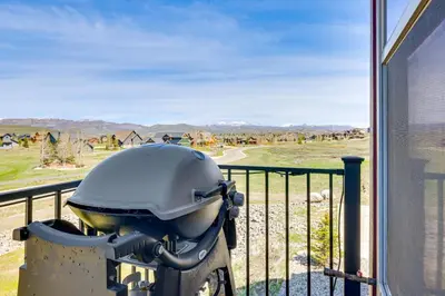 a motorcycle parked on a balcony with a view of a field at Hot Tub and Mtn Views Townhome in Granby! in Granby