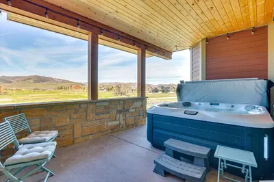 a jacuzzi tub on a patio with a chair at Hot Tub and Mtn Views Townhome in Granby! in Granby