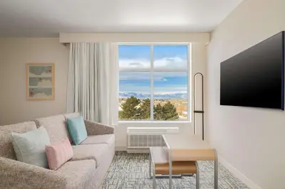 a living room with a couch and a large window at Homewood Suites By Hilton Thornton Denver in Thornton