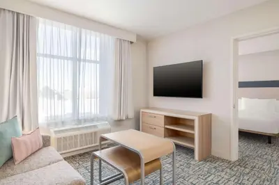 a hotel room with a couch and a tv at Homewood Suites By Hilton Thornton Denver in Thornton