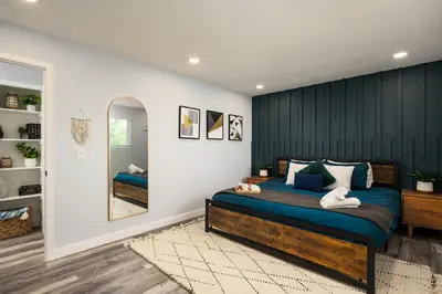 a bedroom with a large bed and a mirror at Denver Emerald - Close to Red Rocks, Arvada & Downtown in Denver