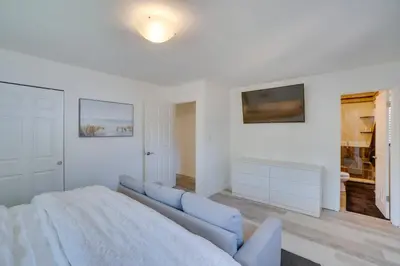 a white living room with a couch and a tv at Covered Patio and Fire Pit Centennial Home! in Centennial