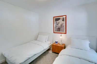 two beds in a room with white walls at Covered Patio and Fire Pit Centennial Home! in Centennial