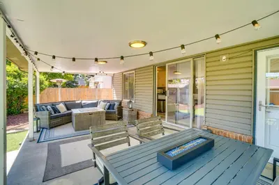 a patio with a table and chairs on a porch at Covered Patio and Fire Pit Centennial Home! in Centennial