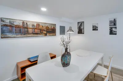 a white dining room with a vase on a table at Sleek and Central Centennial Apartment with Fireplace! in Centennial