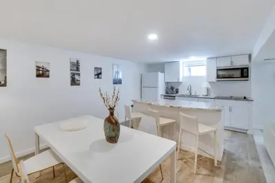 a kitchen and dining room with a white table and chairs at Sleek and Central Centennial Apartment with Fireplace! in Centennial