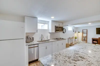 a kitchen with white cabinets and a counter top at Sleek and Central Centennial Apartment with Fireplace! in Centennial