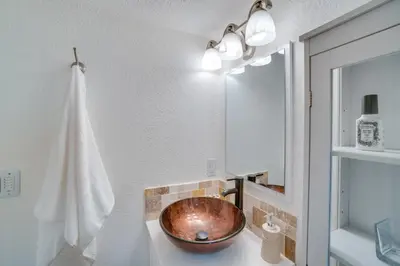 a bathroom with a copper sink and a mirror at Sleek and Central Centennial Apartment with Fireplace! in Centennial