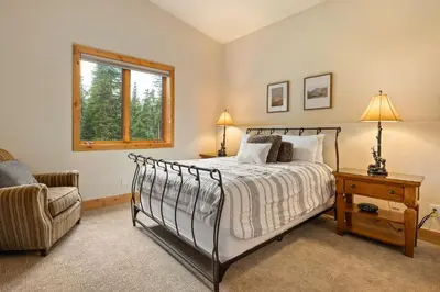 a bedroom with a bed and a chair and a window at 103 Antler Way at Lakota townhouse in Winter Park