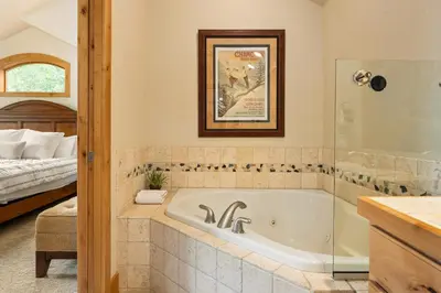 a bathroom with a bath tub and a bed at 103 Antler Way at Lakota townhouse in Winter Park