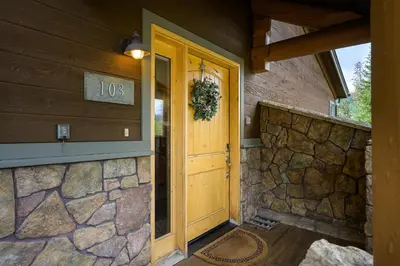 a front door of a house with a stone wall at 103 Antler Way at Lakota townhouse in Winter Park