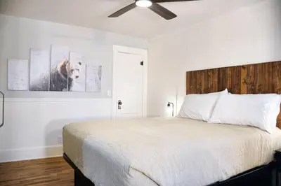 a bedroom with a white bed with a dog on the wall at Mount Chiquita Suite in Estes Park