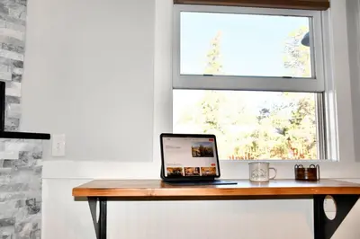 a laptop sitting on a wooden table in front of a window at Mount Chiquita Suite in Estes Park