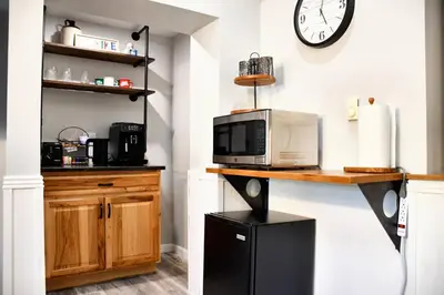 a kitchen with a counter with a microwave and a clock at Mount Chiquita Suite in Estes Park