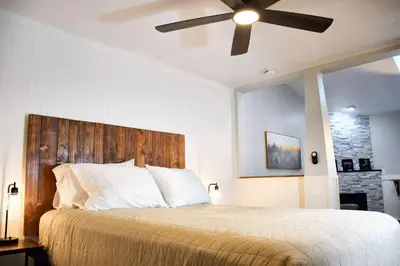 a bedroom with a large bed with a ceiling fan at Mount Chiquita Suite in Estes Park