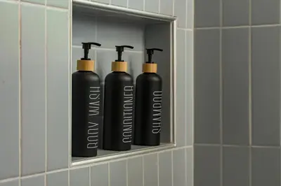 three black water bottles sitting on a shelf in a bathroom at NEW Modern, Luxury Home with Hot Tub, Gym, Sauna, and 12 Minutes to Denver in Arvada