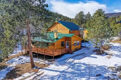 a log cabin in the woods in the snow at House of The Rising Sun in Bailey