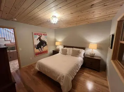 a bedroom with a bed and a poster of a horse at House of The Rising Sun in Bailey