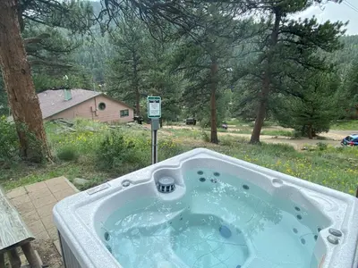 a jacuzzi tub in a backyard with a yard at Rose Den - Romantic Mountain Cabin with Views! in Estes Park
