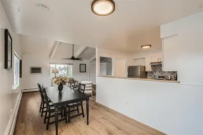 a dining room and kitchen with a table and chairs at Natural Light, High-Vaulted Ceilings Apartment and Garage in Lakewood