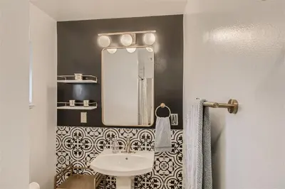 a bathroom with a sink and a mirror at Natural Light, High-Vaulted Ceilings Apartment and Garage in Lakewood