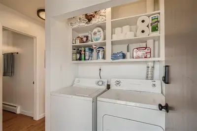 a laundry room with a washer and dryer at Natural Light, High-Vaulted Ceilings Apartment and Garage in Lakewood