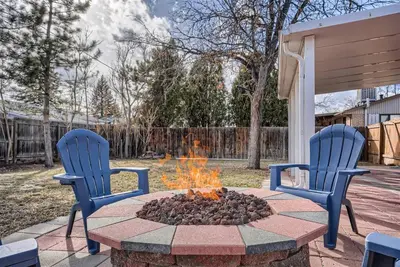 two blue chairs and a fire pit in a yard at Serene, Spacious Home in Quiet Neighborhood with Fenced Yard in Aurora