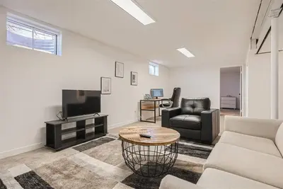 a living room with a couch and a tv and a table at Serene, Spacious Home in Quiet Neighborhood with Fenced Yard in Aurora