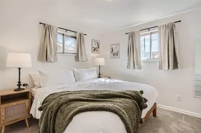 a bedroom with a bed and two windows at Serene, Spacious Home in Quiet Neighborhood with Fenced Yard in Aurora