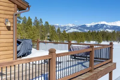 a deck with a fence and mountains in the background at Stagecoach Cabin home in Fraser