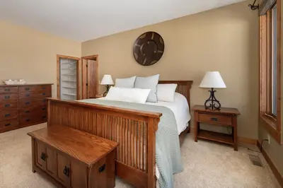 a bedroom with a bed and two tables and a mirror at Stagecoach Cabin home in Fraser