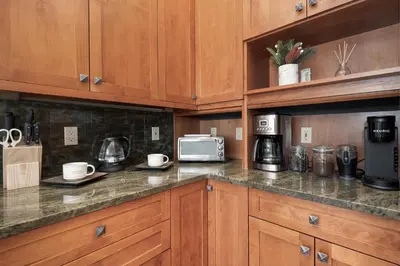 a kitchen with wooden cabinets and a counter top with a microwave at Stagecoach Cabin home in Fraser