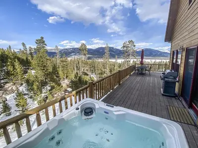 a jacuzzi tub on the deck of a house at Grand Chalet at Grand Lake cabin in Grand Lake