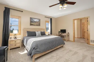 a bedroom with a bed and a ceiling fan at Grand Chalet at Grand Lake cabin in Grand Lake