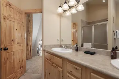 a bathroom with two sinks and a large mirror at Grand Chalet at Grand Lake cabin in Grand Lake