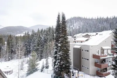 a ski lodge in the snow with trees at Iron Horse C4093 condo in Winter Park