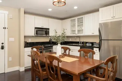 a kitchen with a wooden table and a refrigerator at Base Camp 313 condo in Granby