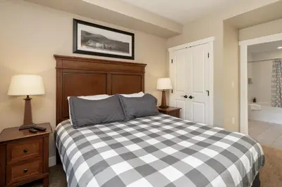a bedroom with a bed with a checkered blanket at Base Camp 313 condo in Granby