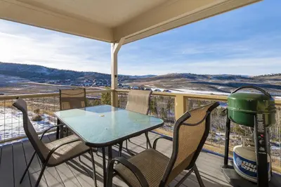 a patio with a table and chairs on a balcony at Peak View Drive townhouse in Granby