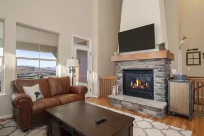 a living room with a couch and a fireplace at Peak View Drive townhouse in Granby