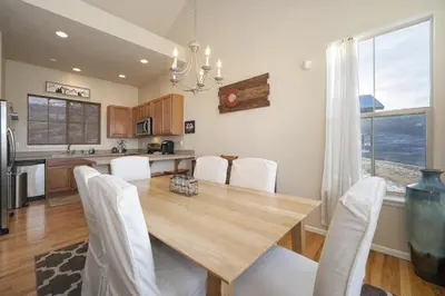 a kitchen and dining room with a wooden table and white chairs at Peak View Drive townhouse in Granby
