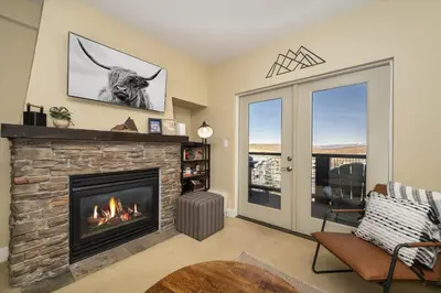 a living room with a fireplace and a window at Base Camp 306 condo in Granby