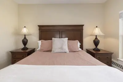 a bedroom with a large bed with two lamps at Base Camp 306 condo in Granby