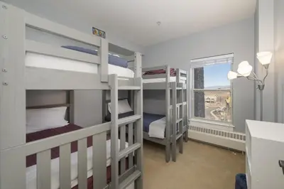 a room with three bunk beds and a window at Base Camp 306 condo in Granby