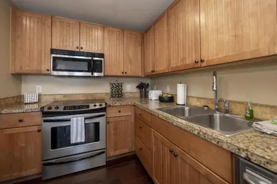 a kitchen with wooden cabinets and a stainless steel sink at Base Camp 306 condo in Granby