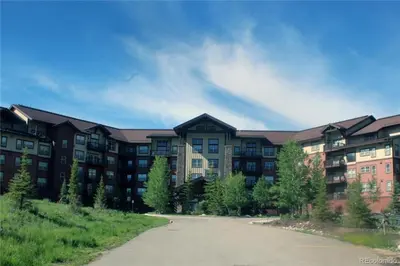 a large apartment building with a road in front of it at Base Camp 306 condo in Granby