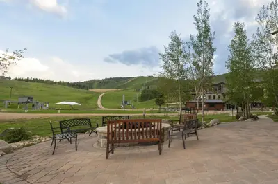 a group of benches sitting on a brick patio at Base Camp 304 condo in Granby