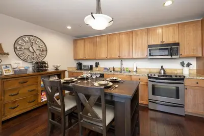 a kitchen with a table and a clock on the wall at Base Camp 304 condo in Granby