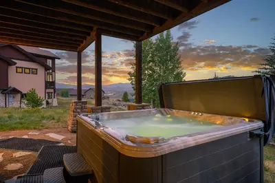 a hot tub on a patio with a view at Indian Trail Cabin cabin in Granby